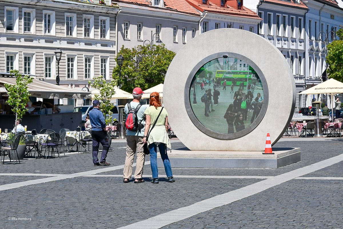 Menschen auf dem Rathausplatz beobachten im Portal Szenen aus einer anderen Stadt