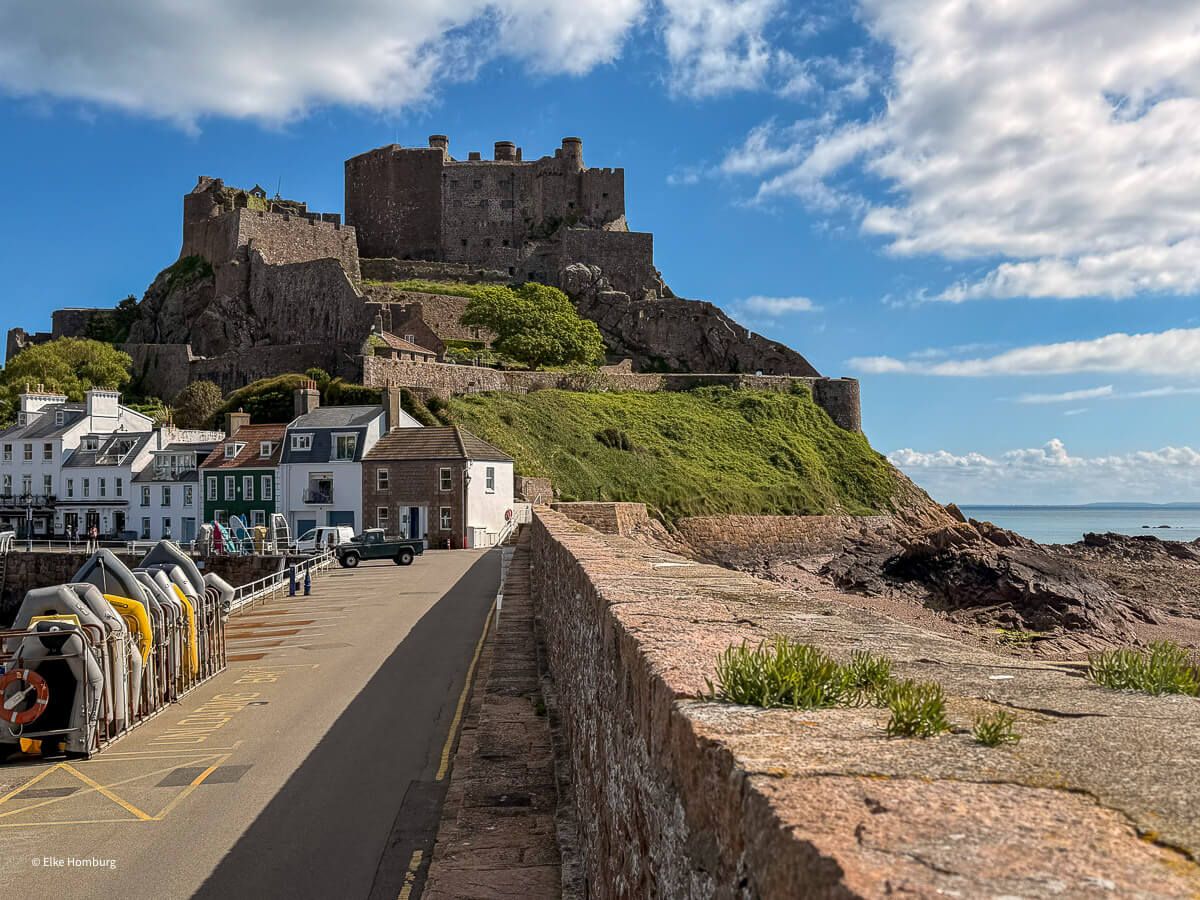 Pier mit Häusern und Burg im Hintergrund