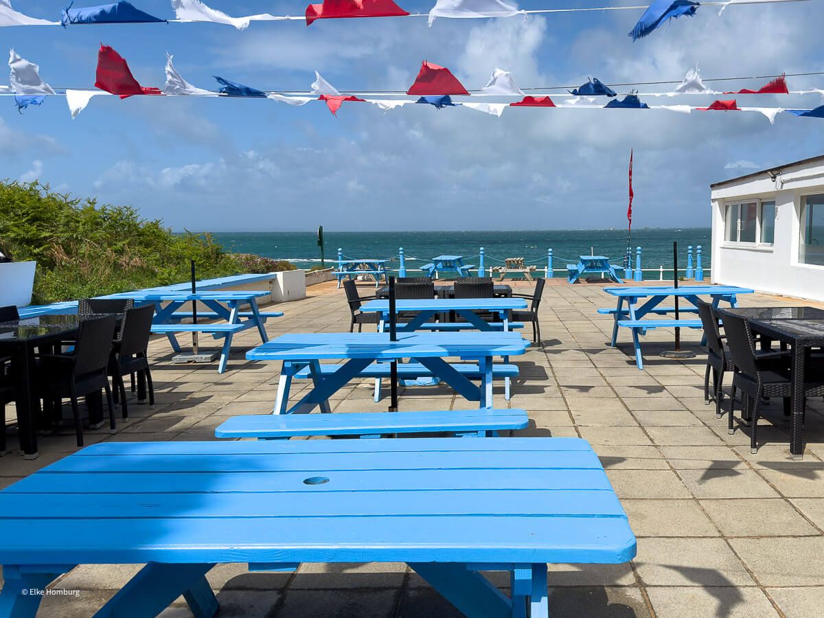 Strandbude mit blauen Tischen und Bänken
