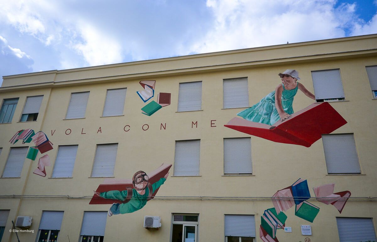 Schule mit Murals und Aufschrift "Flieg mit mir"
