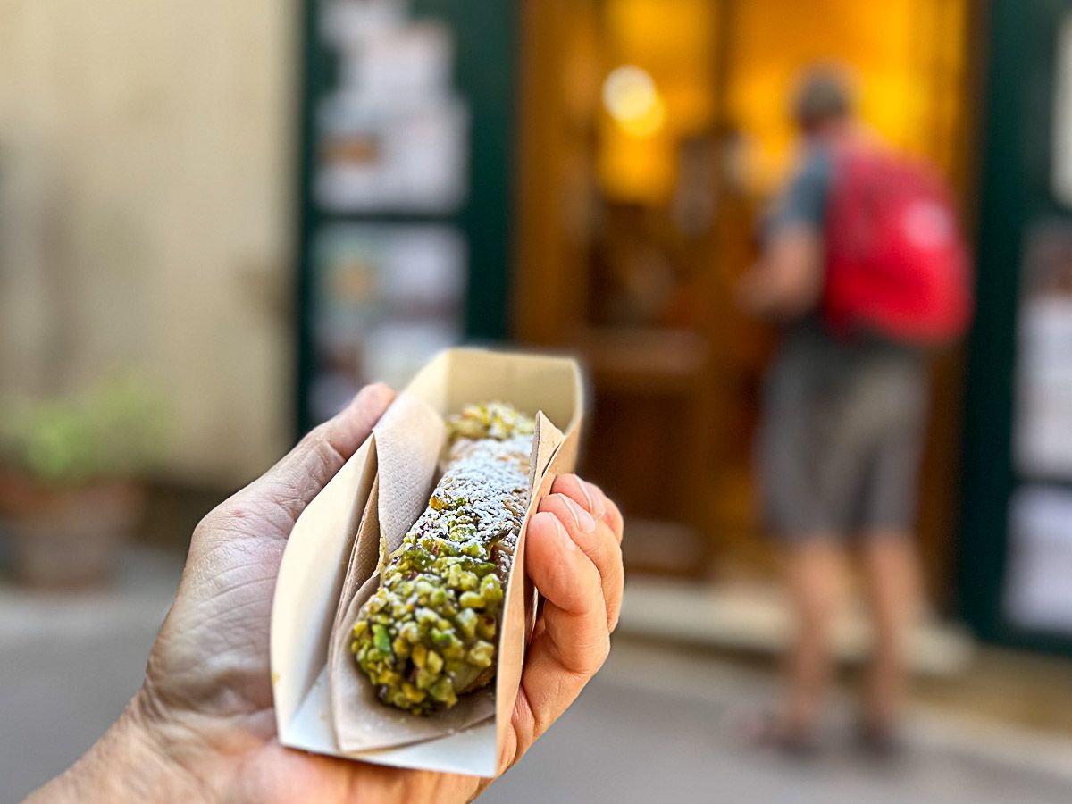 Sehenswürdigkeiten Sizilien: Meine Top 16 auf der Sonneninsel im Mittelmeer 64 Cannoli mit Pistazien in der Hand eines Kunden der Schokolaterie