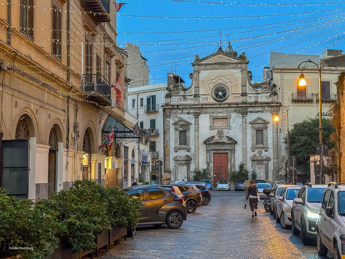 Straße mit abendlicher Beleuchtung und barocken Gebäuden 