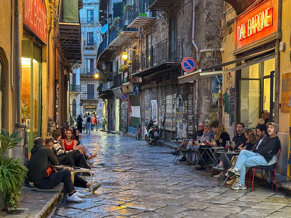 Beleuchtete Gasse im Ausgehviertel mit Gästen in den Bars