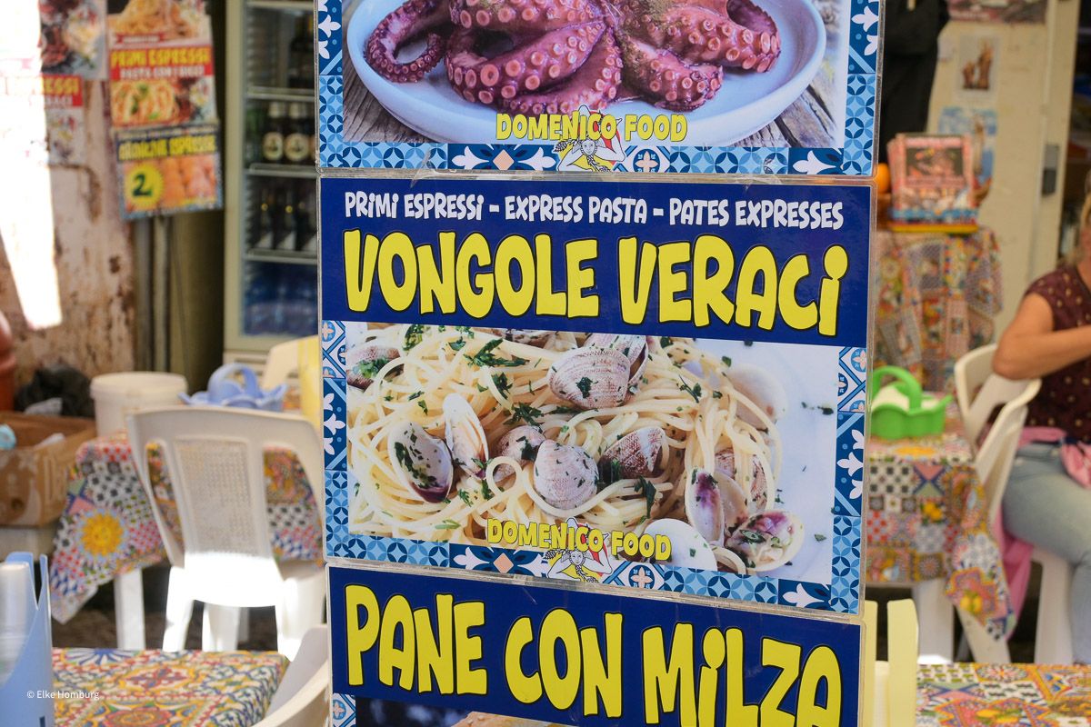 Marktlokal mit Werbung für verschiedene Gerichte
