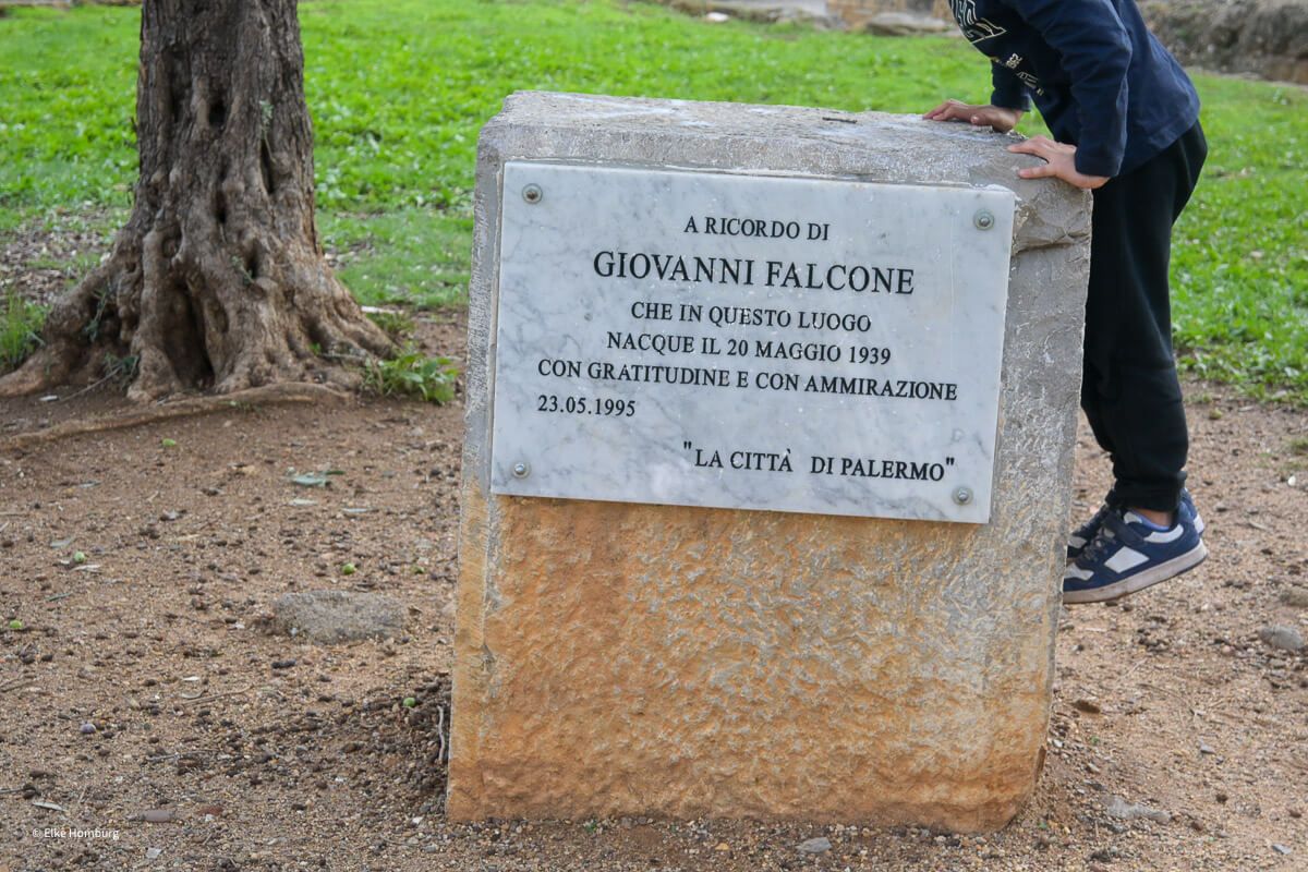 Junge klettert auf ein Denkmal für Falcone